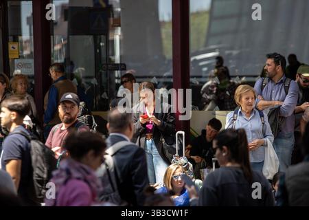 Madrid, Spanien. April 2025. Eine Frau überprüft ihr Handy in der Menge vor dem Bahnhof Atocha in Madrid. Gegen 12:30 Uhr verlor die Iberische Halbinsel ihre Macht. Mehrere Teile Spaniens und Portugals waren von einem allgemeinen Stromausfall betroffen, was zu Chaos auf den Straßen führte. Quelle: SOPA Images Limited/Alamy Live News Stockfoto