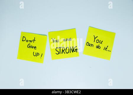 Positive Affirmationen. Sätze in verschiedenen Farben Blätter für Notizen auf grünem Hintergrund. Motivationskonzept mit handgeschriebenem Text. Stockfoto