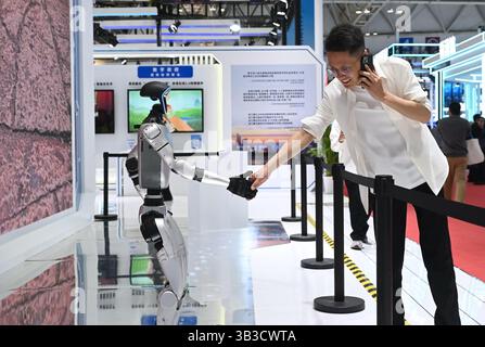 Peking, Chinas Provinz Fujian. April 2025. Ein Besucher interagiert mit einem humanoiden Roboter im Erlebnisbereich des 8. Digital China Summit in Fuzhou, südöstlicher Provinz Fujian, 28. April 2025. Mit der Teilnahme von mehr als 300 professionellen Institutionen öffnete der 8. Digital China Summit seinen Erfahrungsbereich am Montag für Fachbesucher und stellte die Erfolge des Landes im digitalen Wandel vor, während das robuste Wachstum im digitalen Sektor zunimmt. Quelle: Lin Shanchuan/Xinhua/Alamy Live News Stockfoto