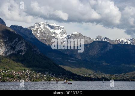 Ein wunderschöner Blick auf den Berg La Tournette über dem See Annecy (Lac d'Annecy) in Frankreich, mit Freizeitbooten auf dem Wasser und dramatischen Wolken darüber. Stockfoto