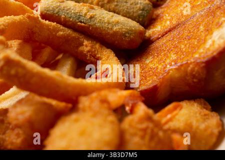 Eine Nahaufnahme mehrerer Sorten frittierter Vorspeisen, darunter Texas Toast, Zwiebelringe und Zucchini-Sticks. Stockfoto
