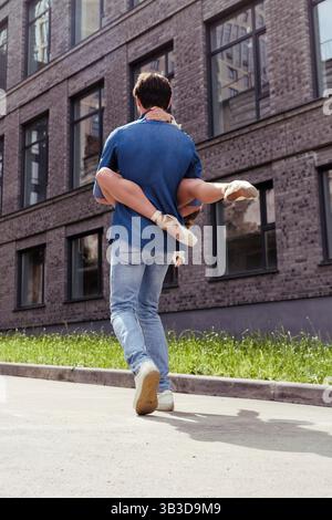 Ein verliebter Partner trifft auf eine Ballerina auf einer Straße, während er an einem Sommertag durch die Stadt spaziert Stockfoto