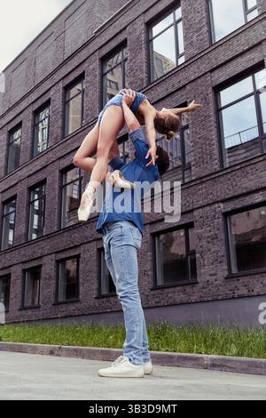 Ein verliebter Partner trifft auf eine Ballerina auf einer Straße, während er an einem Sommertag durch die Stadt spaziert Stockfoto