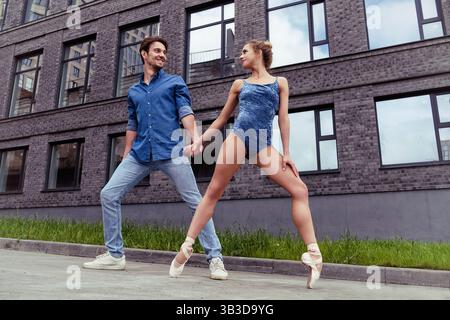Ein verliebter Partner trifft auf eine Ballerina auf einer Straße, während er an einem Sommertag durch die Stadt spaziert Stockfoto