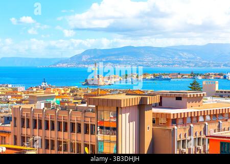 Blick auf Messina, Sizilien, mit modernen Gebäuden im Vordergrund, der berühmten Madonna della Lettera Statue und der Straße von Messina im Hintergrund Stockfoto