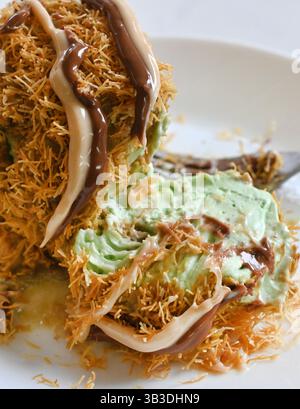 Eiskugel bedeckt mit Kadayif und Schokolade Stockfoto