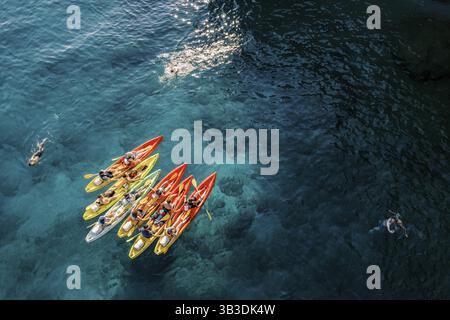 Touristen schwimmen im türkisfarbenen Meer in der Nähe eines Teams von Kajakfahrern in Kajaks. DROHNE., Ð¥ Ð¾Ñ€Ð²Ð°Ñ‚Ð¸Ñ Stockfoto