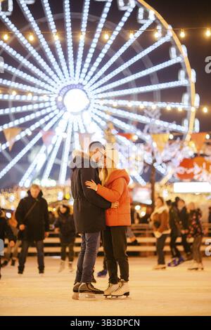 Verliebtes Paar. Romantische Charaktere für Valentinstag. Wahre Liebe. Glückliches Paar, das sich am Abend auf der Eislaufbahn in der Stadt amüsiert. Fröhlich romantisch Stockfoto