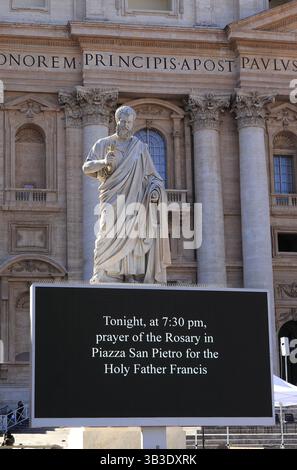 Petersstatue mit elektronischem Bildschirm, der die Gebetsvorlesung für Papst Franziskus auf dem Petersplatz in Rom, Italien, März 2025 ankündigt. Stockfoto