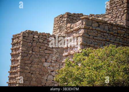 Aus nächster Nähe sehen Sie eine alte römische Steinmauer, die verwitterte Texturen, kompliziertes Mauerwerk und zeitlose Handwerkskunst römischer Architektur zeigt Stockfoto