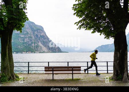 Lecco, Italien - 01.05.2023: Mann, der schnell in Lungolago di Lecco läuft. Gesunder Lebensstil Stockfoto
