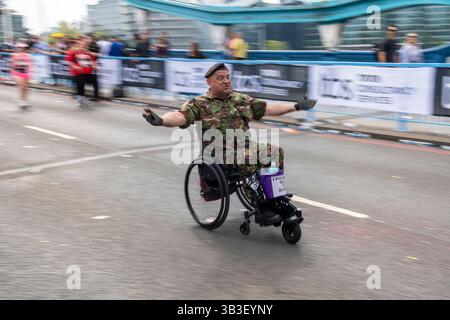 2025 Rollstuhlteilnehmer des London Marathon, der über die 12-km-Etappe der Tower Bridge kommt Stockfoto