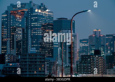 Nächtlicher Blick auf das Umeda Sky Building in Osaka, Japan, von einer Brücke mit Blick auf die Stadtlandschaft. Stockfoto