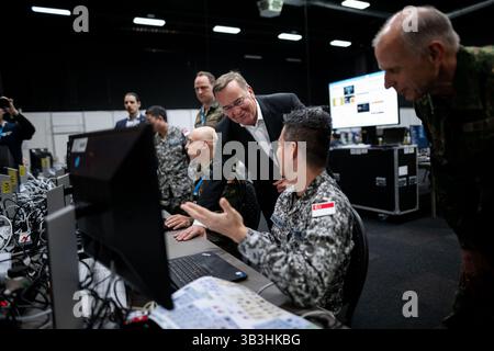 29. April 2025, Nordrhein-Westfalen, Kalkar: Bundesverteidigungsminister Boris Pistorius (SPD, M) spricht während der Übung mit einem Soldaten aus Singapur. Die multinationale NATO-Übung "Locked Shields" findet im Ausstellungs- und Kongresszentrum Kalkar statt. Diese Übung ist derzeit die weltweit größte, komplexeste und fortschrittlichste multinationale NATO-Übung im Bereich der Cybersicherheit. Foto: Fabian Strauch/dpa Stockfoto