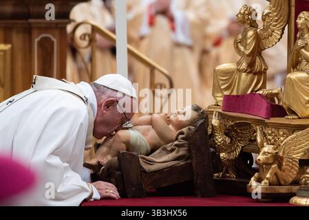 Papst Franziskus küsst während der Messe ein Jesuskind in St. Peter Basilca Stockfoto