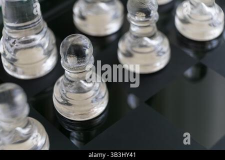 Glaspflöckchen auf einem Glasschachbrett Stockfoto