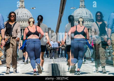London, Großbritannien. April 2025. Nach dem Marathon gibt es auf der Millennium Bridge zahlreiche Jogger aller Formen und Größen. Eine Mini-Hitzewelle im Frühsommer führt zu warmem, sonnigem Wetter und die Außenbereiche in London sind sehr voll. Guy Bell/Alamy Live News Stockfoto