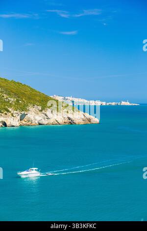 Touristenboot in der Bucht von San Felice mit einem Naturbogen (Architello) an der Küste von Gargano, Apulien, Italien. Stockfoto