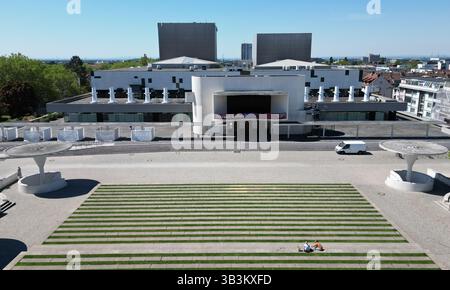 Darmstadt, Deutschland. April 2025. Schirmsäulen aus weißem Sichtbeton, die die Eingänge zur Tiefgarage beidseitig des Georg-Büchner-Platzes markieren, bilden ein markantes Ensemble vor dem Staatstheater (Luftsicht mit Drohne). Das Staatstheater ist ein vierteiliger Veranstaltungsort für Musik- und Tanztheater, Theater und Konzerte und wurde 2006 nach einer Umgestaltung wiedereröffnet. Vermerk: Arne Dedert/dpa/Alamy Live News Stockfoto
