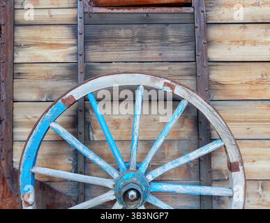 Ein altes Pferdewagenrad vor hölzernem Hintergrund. Nahaufnahme des Vintage-Wagens Stockfoto