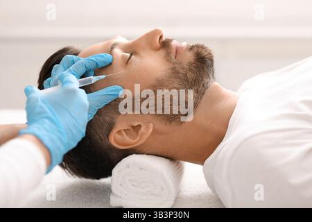 Kosmetologe macht Hebeverfahren für Mann mittleren Alters Stockfoto