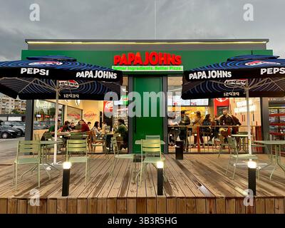 Gäste essen drinnen in einem Papa Johns Pizzeria Restaurant Pizzeria in einem Supermarkt Parkplatz in Sofia Bulgarien mit sichtbarem Sitzbereich im Freien. Stockfoto