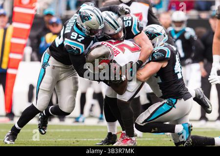 24. Dezember 2017: Tampa Bay Buccaneers Running Back Peyton Barber (25) wird von Carolina Panthers Defensive End Mario Addison (97), Middle Linebacker Luke Kuechly (59) und Free Safety Colin Jones (42) im NFL Matchup zwischen Tampa Bay und Carolina im Bank of America Stadium in Charlotte, NC, überschwemmt. (Scott Kinser/Cal Sport Media)(Credit Image: &Copy; Scott Kinser/CSM via ZUMA Wire) Stockfoto