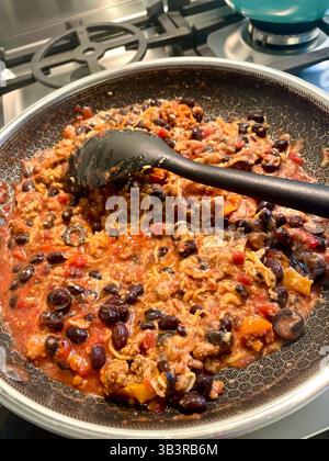 Schwarze Bohnen und Reis ist ein traditionelles mexikanisches Gericht, das in einer Pfanne mit Herd gekocht wird, 2025, USA Stockfoto