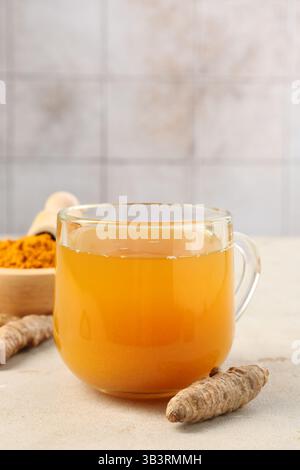 Aromatischer Kurkuma-Tee, Rhizome und Pulver auf weißem texturiertem Tisch, Nahaufnahme. Leerzeichen für Text Stockfoto