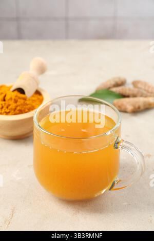 Aromatischer Kurkuma-Tee, Rhizome und Pulver auf weißem texturiertem Tisch, Nahaufnahme. Leerzeichen für Text Stockfoto