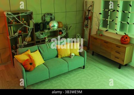 Stilvolles Wohnzimmer mit Diskokugel und weichem Sofa für Halloween-Party in der Nacht Stockfoto