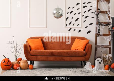 Stilvolles Wohnzimmer mit Diskokugel und braunem Sofa für Halloween-Party Stockfoto