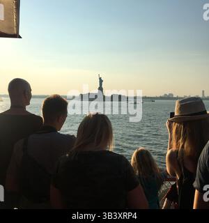 Touristen, die sich die Freiheitsstatue in New York City, USA ansehen Stockfoto