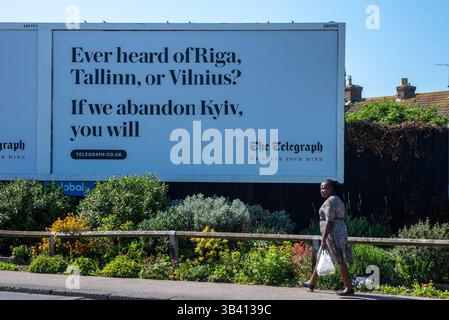 Birchington, Großbritannien. April 2025. Ein Fußgänger läuft durch das Telegraph-Kampagnenplakat in Birchington. Die neue Telegraph Reklametafelkampagne hebt die russischen Leckerbissen in Bezug auf die baltischen Länder (Lettland, Estland und Litauen) hervor, falls die Ukraine vom Vereinigten Königreich und den anderen westlichen Ländern im Stich gelassen wird. (Credit Image: © Krisztian Elek/SOPA Images via ZUMA Press Wire) NUR REDAKTIONELLE VERWENDUNG! Nicht für kommerzielle ZWECKE! Stockfoto