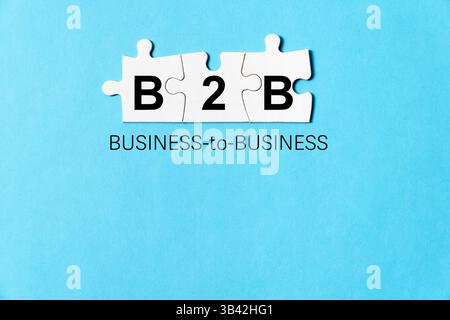 Geschäftskonzept-Bild mit Buchstaben B2B auf weißen Puzzles bedeutet Business to Business, isoliert auf blauem Hintergrund Stockfoto