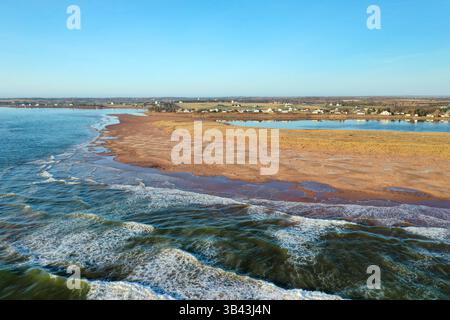 Luftaufnahme, die den Kontrast zwischen dunklen Meereswellen und strahlend weißem Meereshahn festmacht, Prinz edward Island Canada. Hochwertige Fotos Stockfoto