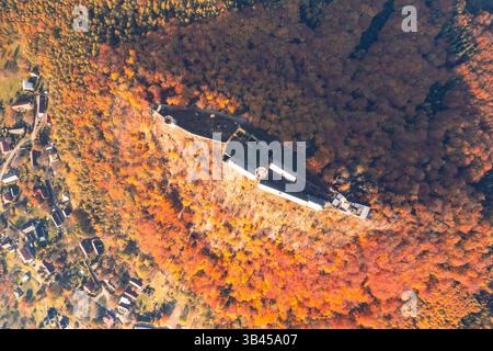 Inmitten lebendiger Herbstbäume steht Bezdez Castle stolz. Die Luftperspektive zeigt die historische Architektur des Schlosses, umrahmt von bunten Herbstblättern. Stockfoto