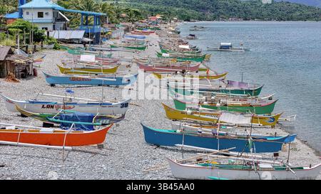 Mabua Beach, Surigao Philippinen, farbenfrohe traditionelle Fischerboote säumen den Strand. Stockfoto