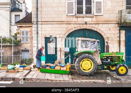 Marktmann, der seine eigenen Produkte auf einem Gehweg hinter seinem Traktor legt - Preuilly-sur-Claise, Indre-et-Loire (37), Frankreich. Stockfoto