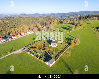 Die Tesarov-Kapelle ist von einem kleinen Friedhof in Korenov umgeben, eingebettet in das Isergebirge. Die ruhige Landschaft bietet einen Einblick in das ländliche Leben und die Natur. Stockfoto