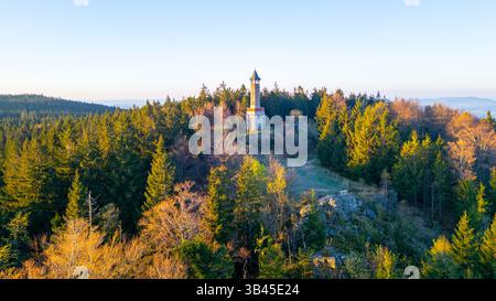 Der Stepanka Aussichtsturm steht hoch zwischen grünen Bäumen im Isergebirge. Das klare Morgenlicht des Frühlings beleuchtet die Landschaft, schafft eine ruhige Atmosphäre und lädt zum Erkunden ein. Stockfoto
