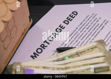 Dokumentieren Sie eine Hypothekenurkunde zusammen mit Bargeld- und Finanznotizen auf einem Schreibtisch, die Immobiliengeschäfte anzeigen. Stockfoto