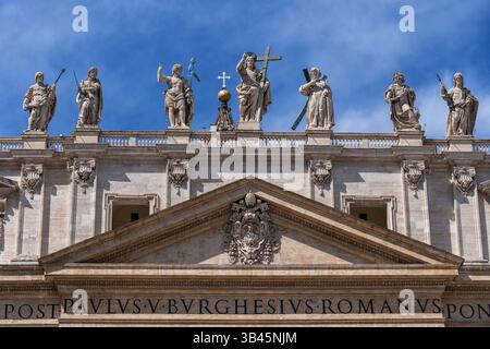 Statue von Christus dem Erlöser in der Mitte mit St. Johannes dem Täufer zu seiner Rechten und St. Andreas zu seiner Linken über St. Peter's Basilika Giebel mit Stockfoto