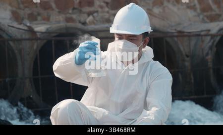 Ökologe, der Wasser giftiger Chemikalien vom Flusspalast auf einem digitalen Tablet entnimmt Stockfoto