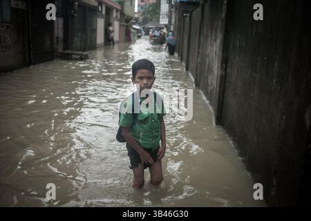 1. September 2015 - ein Junge kehrt während der Flutflut in Chittagong von der Schule zurück...die Flutflut verwüstet den größten Teil des Gebiets von chittagong city.millions Menschen, die in der Flutflut gestürzt sind und das Leben stillsteht...in den letzten Jahren stieg die Flutwasserstände â€“ deutlich über die Gezeitenwerte, die die Astronomie vorhersagt - hat begonnen, die Stadt zweimal am Tag zu beeinflussen, was zu häufigen Überschwemmungen von Wohn- und Geschäftsbereichen führt... wenn sich die Dinge weiter verschlechtern, die meisten Gebiete von Chittagong könnten in naher Zukunft vollständig untergetaucht werden. Eine Studie der Weltbank, die Ju freigelassen wurde Stockfoto