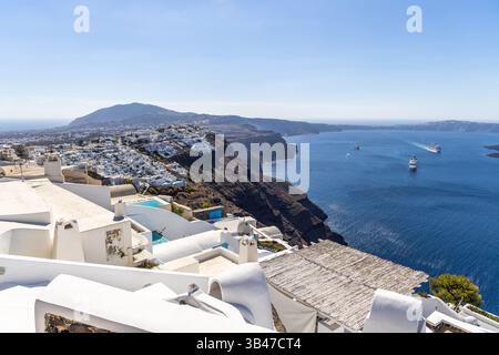Santorini's Cliffside Vista: Weitläufiger Blick auf weiß getünchte Gebäude und die Ägäis. Stockfoto