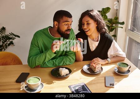 Ein afroamerikanisches Paar genießt Desserts und Drinks, während es Lächeln und Lachen teilt. Stockfoto
