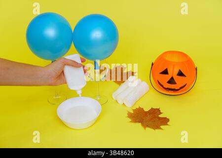 DIY Halloween-Geisterbasteln aus Verbandskleim und Leim. Gießen Sie den Klebstoff ein. Schritt 2: Stockfoto