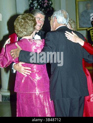 16. November 1988 - US-Präsident Ronald Reagan, Premierministerin Margaret Thatcher und ihre Ehegatten. Abendessen zu Margaret Thatchers Ehren, Weißes Haus, Washington DC, Amerika - 16. November 1988. US-Präsident Ronald Reagan und Premierministerin Margaret Thatcher aus Großbritannien und ihre Ehegatten umarmen sich, nachdem sie nach dem Abendessen in der Eingangshalle des Weißen Hauses in Washington, D.C. einen Tanz teilgenommen haben. Thatcher starb am 8. April 2013 um 87 Uhr an einem Schlaganfall. (Kreditbild: ©Ron Sachs/CNP via ZUMA Wire) Stockfoto