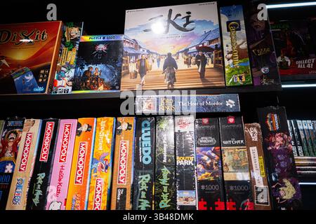 Iwano-Frankiwsk, Ukraine - 29. April 2025: Verschiedene Brettspiele und Puzzles ordentlich auf einem Holzregal in einem Geschäft angeordnet. Stockfoto
